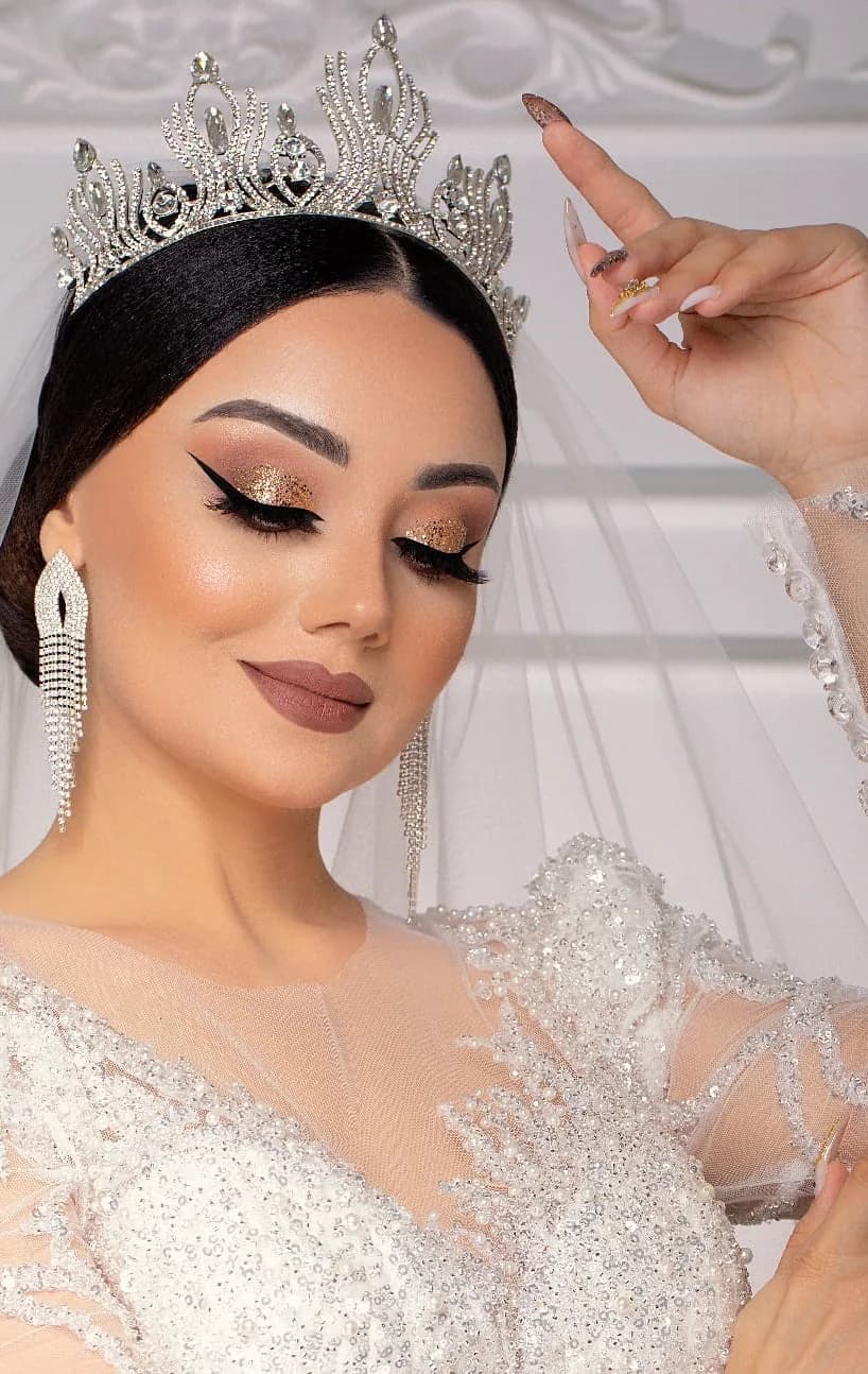 A gold graphic liner under a crown and veil, close up